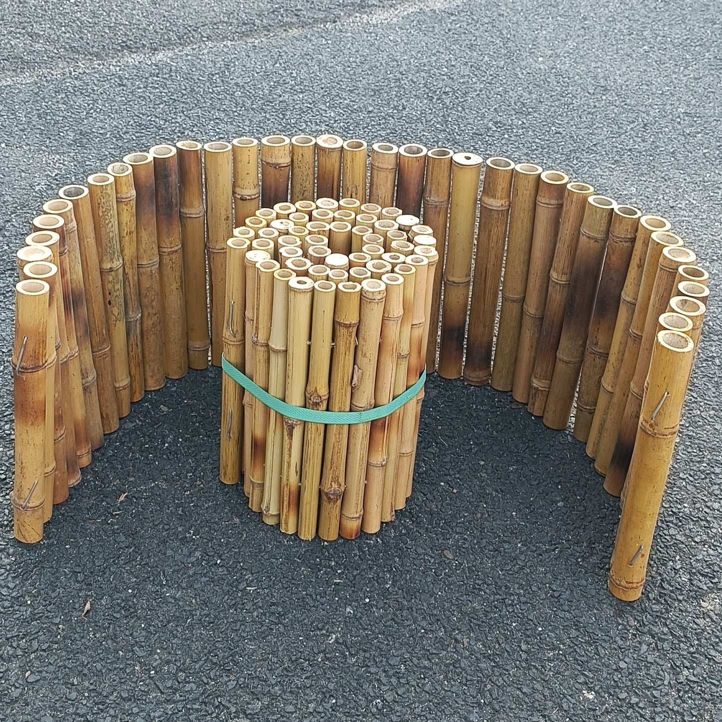 Beeteinfassung oder Verkleidung aus Bambus in Halbkreisform.