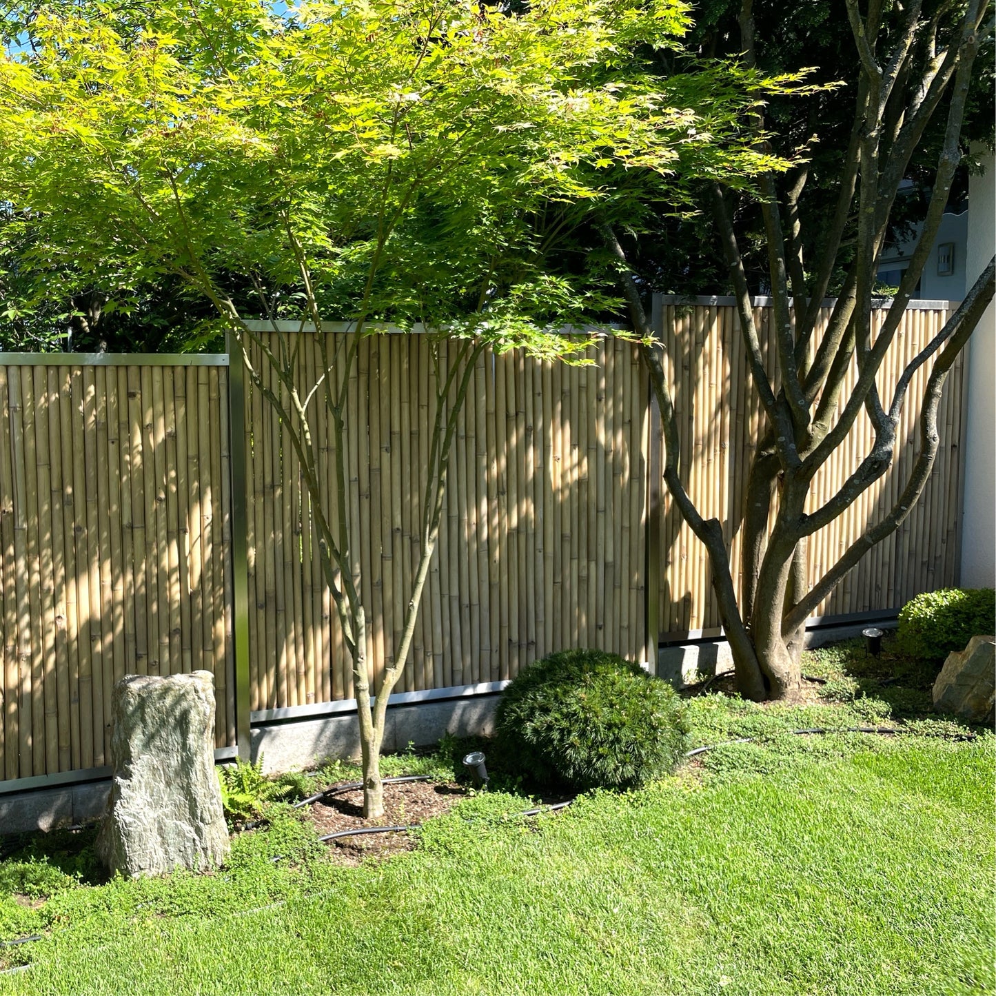 Bambus-Edelstahl-Sichtschutz mit Montageprofilen zur seitlichen Befestigung an den Pfosten.