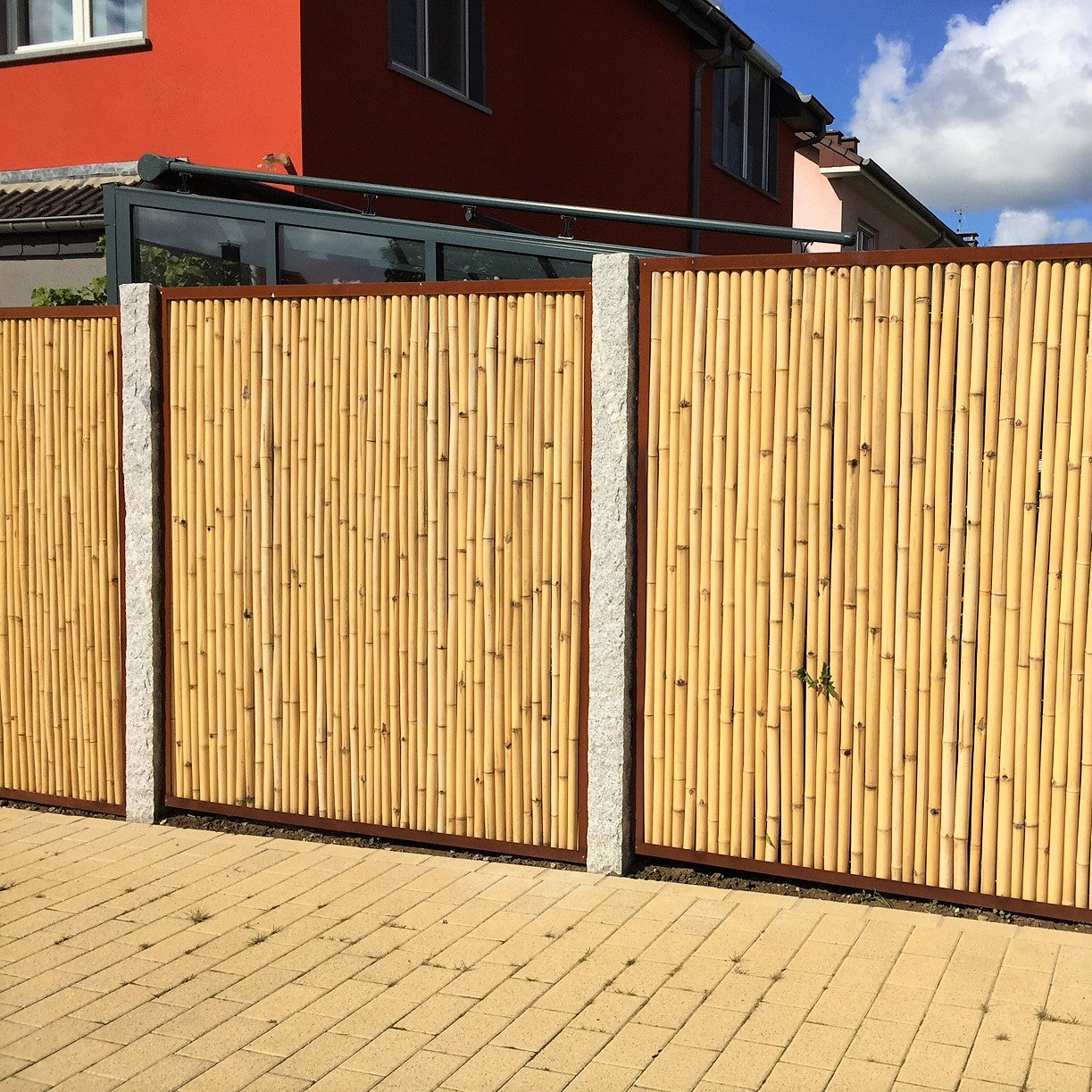 Bambus-Sichtschutzellement im Cortenstahlrahmen zwischen Granit Palisaden