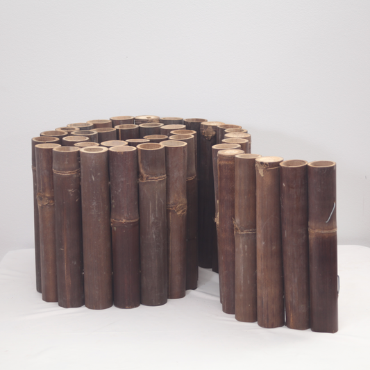 Beeteinfassung aus ganzen dunklen Bambusrohren.